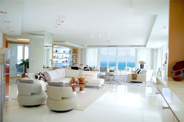 tiled living area featuring a wall of windows, a water view, and a wealth of natural light