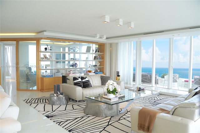 living room featuring a water view, tile patterned floors, and floor to ceiling windows