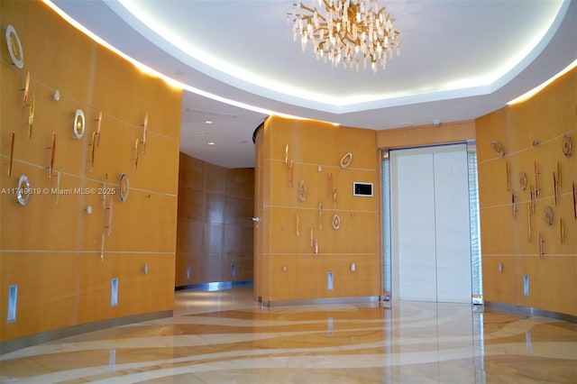 empty room featuring a raised ceiling and tile walls