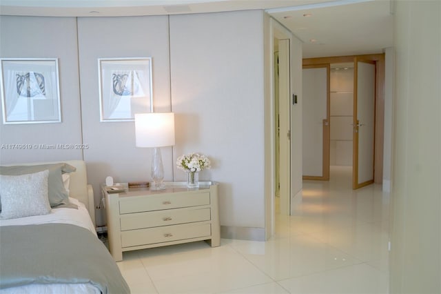 bedroom featuring baseboards and light tile patterned floors