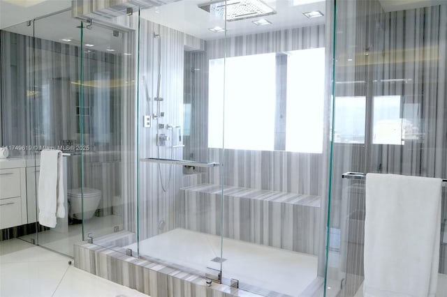 bathroom with toilet, a shower stall, and tile patterned flooring