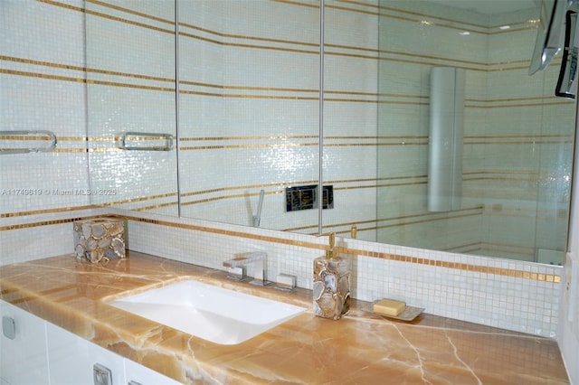 bathroom with tasteful backsplash and vanity