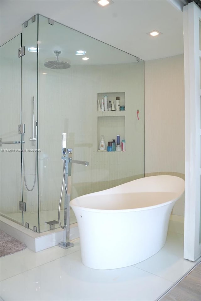 bathroom with a soaking tub, a shower stall, and built in features