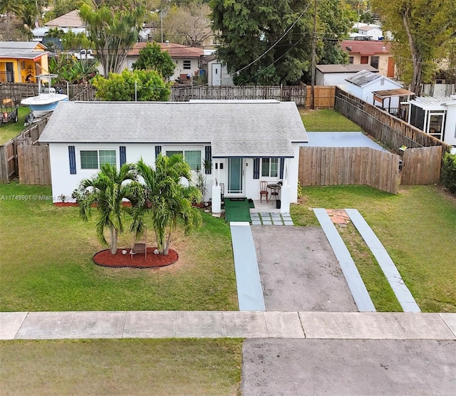 view of front of home with fence private yard, a front yard, roof with shingles, and stucco siding