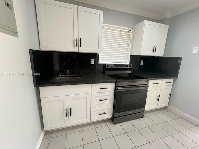 kitchen with dark countertops, white cabinetry, stainless steel electric stove, and backsplash