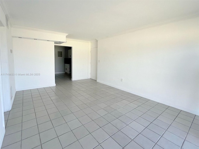 empty room with baseboards, a barn door, and crown molding