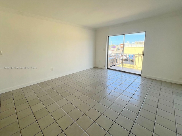 empty room with baseboards, light tile patterned flooring, and crown molding