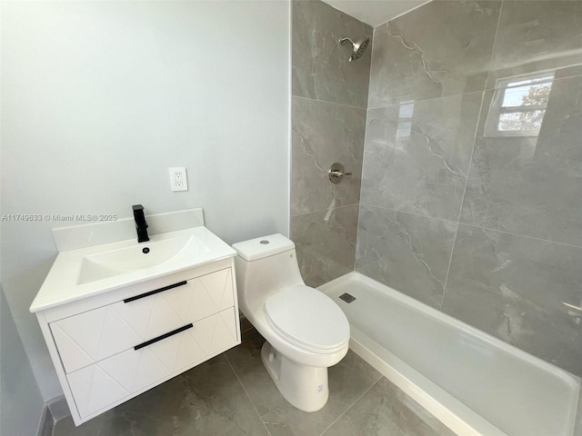 full bath with a tile shower, vanity, and toilet