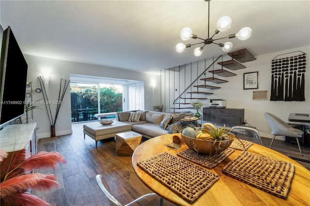 living room featuring an inviting chandelier, stairs, baseboards, and hardwood / wood-style floors