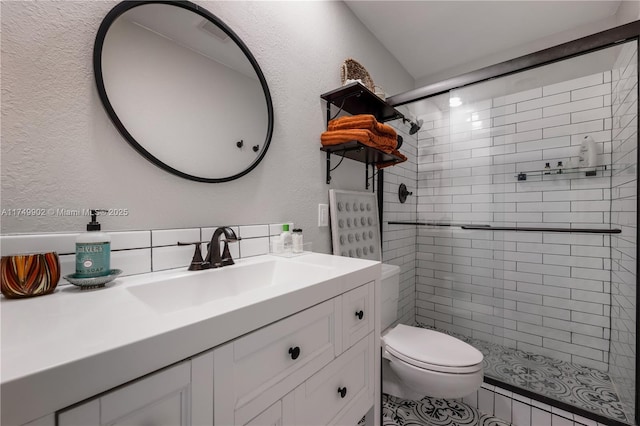 bathroom with visible vents, a textured wall, toilet, vanity, and a shower stall