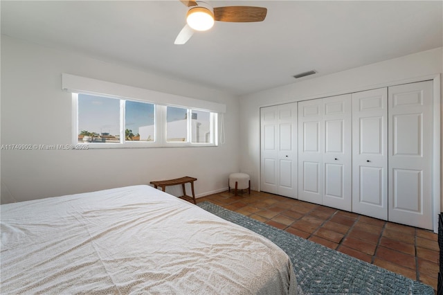 tiled bedroom with a ceiling fan, a closet, and visible vents