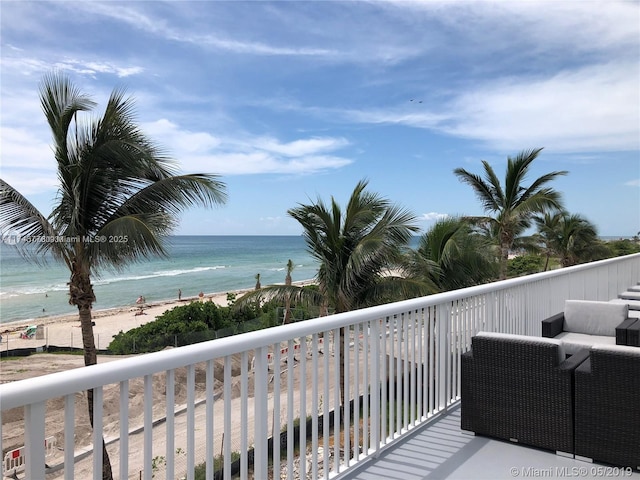 balcony featuring a water view and a view of the beach