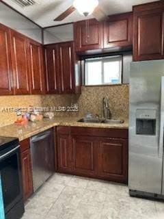 kitchen with ceiling fan, a sink, light countertops, appliances with stainless steel finishes, and decorative backsplash