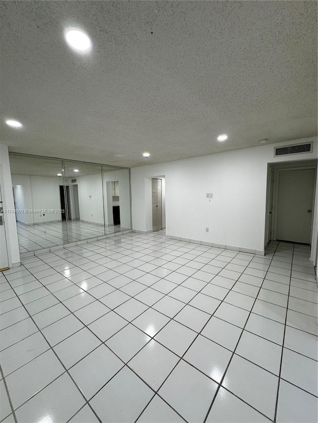 unfurnished room with recessed lighting, light tile patterned flooring, visible vents, and a textured ceiling