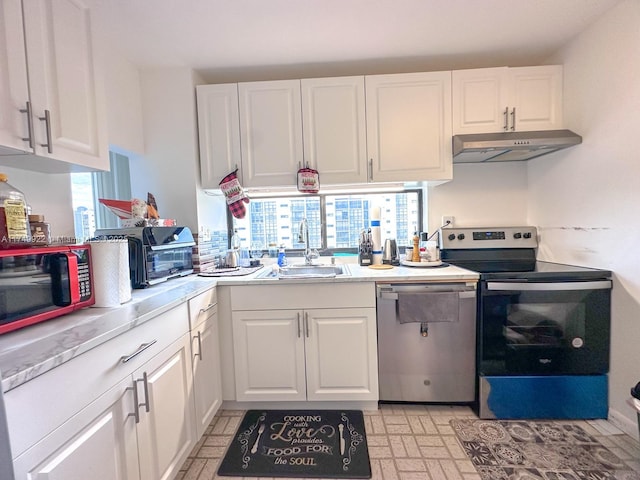 kitchen with appliances with stainless steel finishes, white cabinets, light countertops, and under cabinet range hood