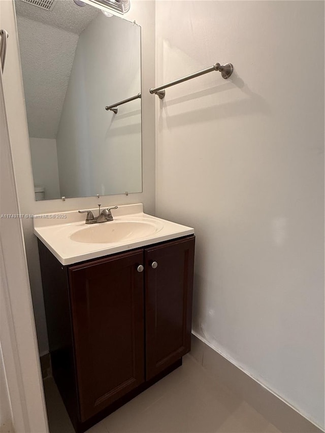 bathroom featuring vanity, a textured ceiling, and visible vents