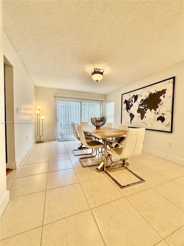 dining area with a textured ceiling, tile patterned floors, and baseboards