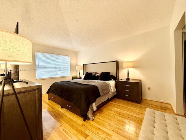 bedroom with a textured ceiling and light wood-type flooring