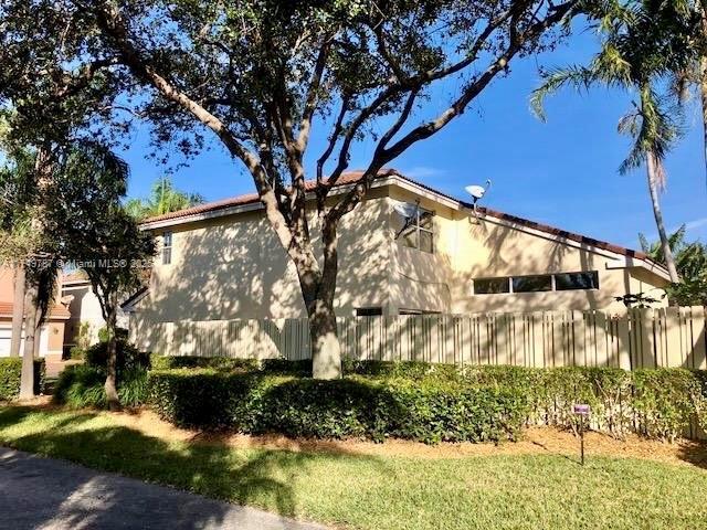 view of side of home featuring stucco siding and fence