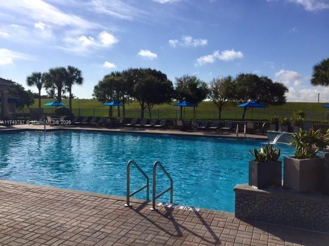pool featuring fence and a patio area