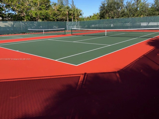 view of tennis court featuring fence and community basketball court