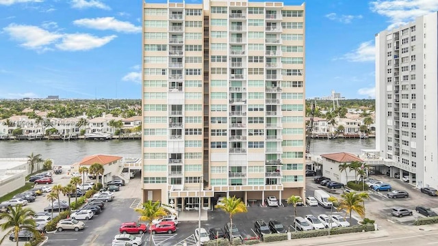 view of building exterior featuring uncovered parking and a water view