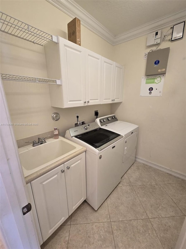 laundry room featuring crown molding, light tile patterned floors, cabinet space, a sink, and washer and dryer