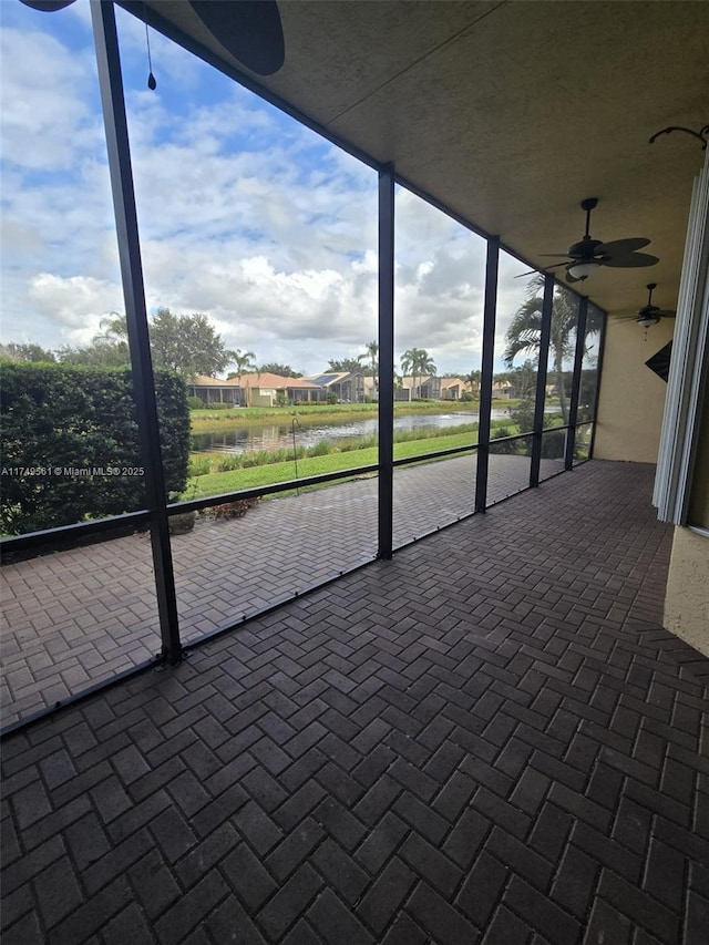 unfurnished sunroom featuring ceiling fan