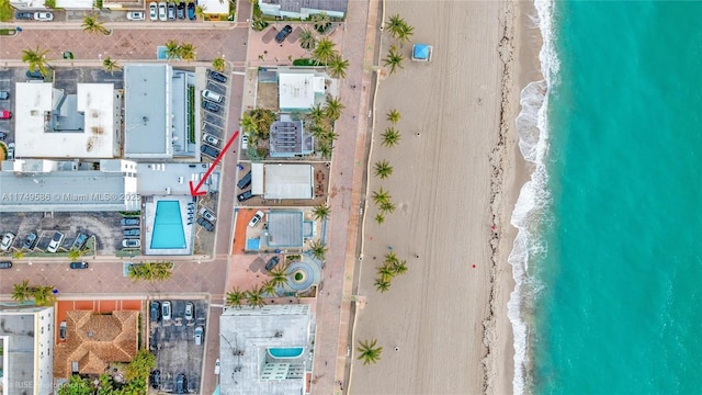 bird's eye view featuring a water view and a beach view