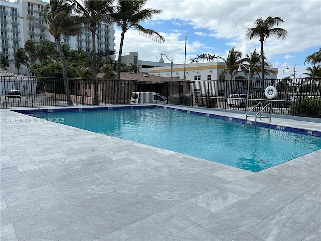 pool with a patio and fence