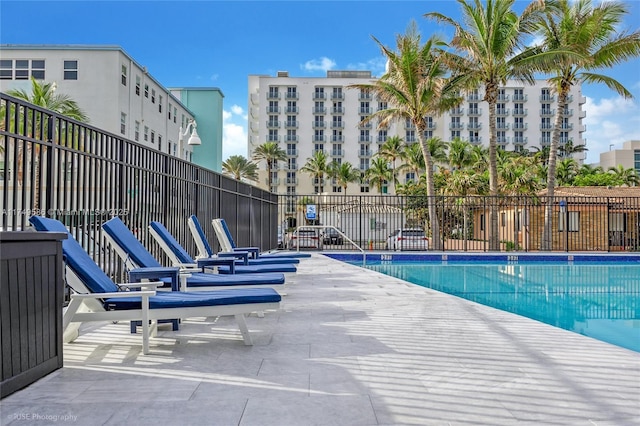 community pool with fence and a patio