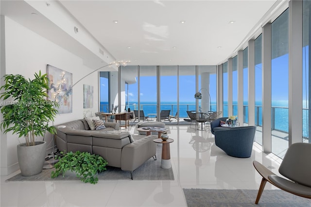 living area with a wealth of natural light, expansive windows, a water view, and light tile patterned flooring