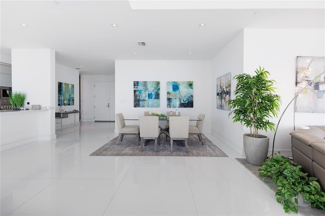 dining room featuring light tile patterned floors, visible vents, and baseboards