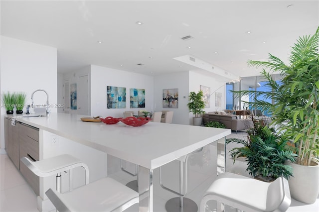 kitchen featuring a peninsula, a kitchen breakfast bar, open floor plan, light countertops, and modern cabinets