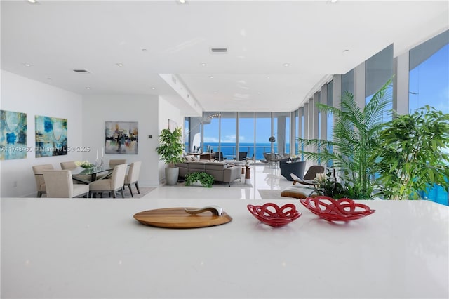 dining area with a water view, expansive windows, and visible vents