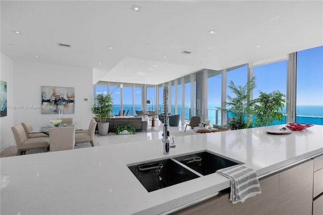 kitchen featuring floor to ceiling windows, recessed lighting, a water view, open floor plan, and modern cabinets