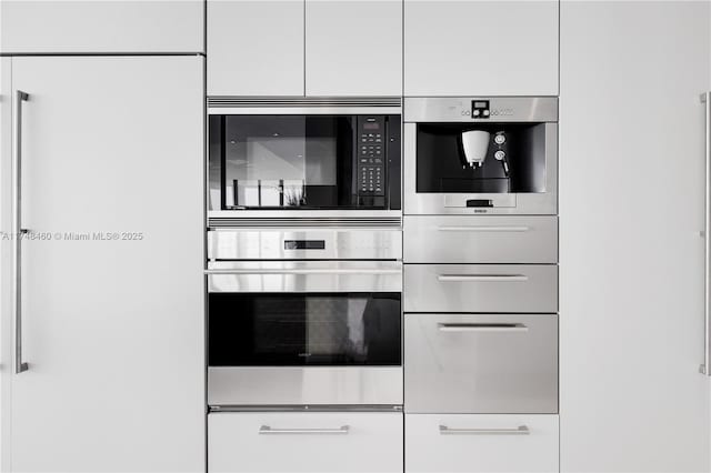 interior space featuring appliances with stainless steel finishes and white cabinets