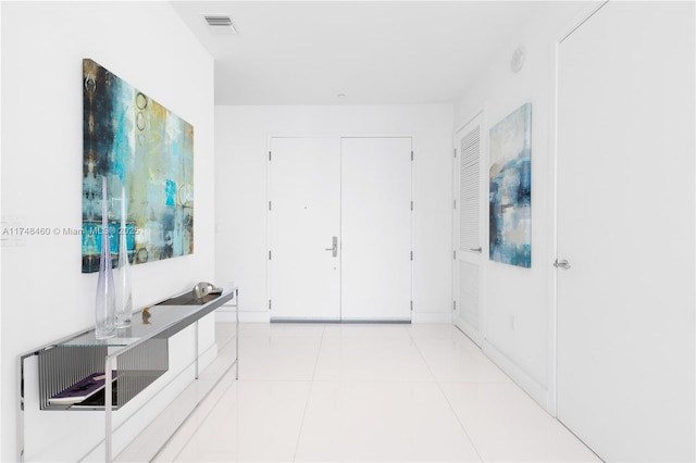 corridor featuring visible vents and light tile patterned floors