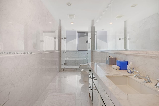 bathroom featuring a tub with marble appearance, a bidet, tile walls, and vanity