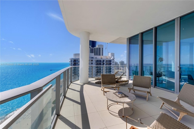 balcony with a view of city, a water view, and a beach view