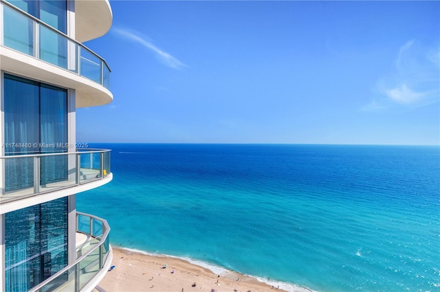 view of pool featuring a water view and a beach view