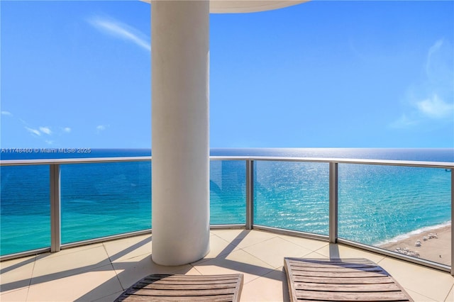 balcony featuring a water view and a beach view