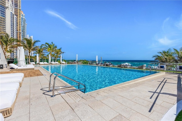 pool with a water view and a patio