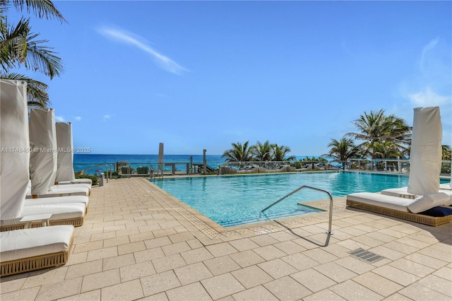 pool with a patio area and a water view