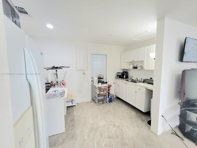 kitchen with recessed lighting, a sink, visible vents, white cabinetry, and light countertops