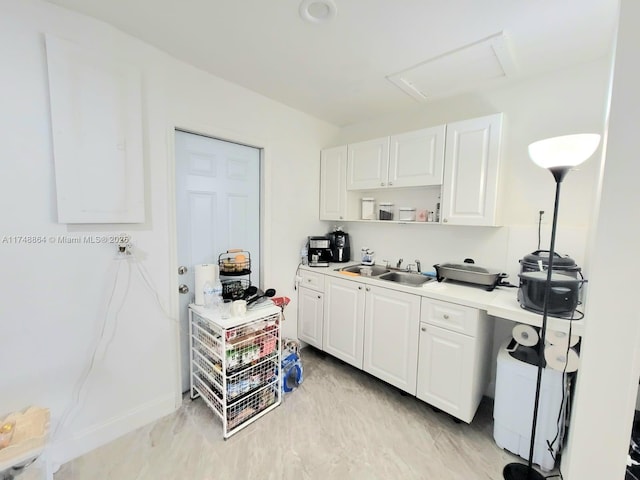 kitchen featuring light countertops, open shelves, a sink, and white cabinetry