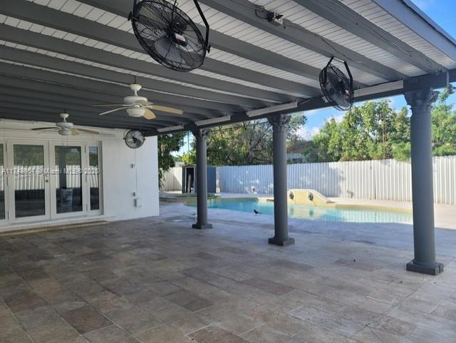 view of patio / terrace featuring french doors, a fenced backyard, a ceiling fan, and a fenced in pool