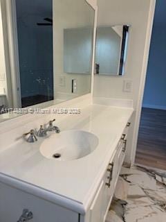 bathroom with marble finish floor and vanity