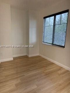 empty room with baseboards and light wood finished floors