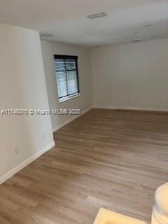 spare room featuring baseboards and wood finished floors